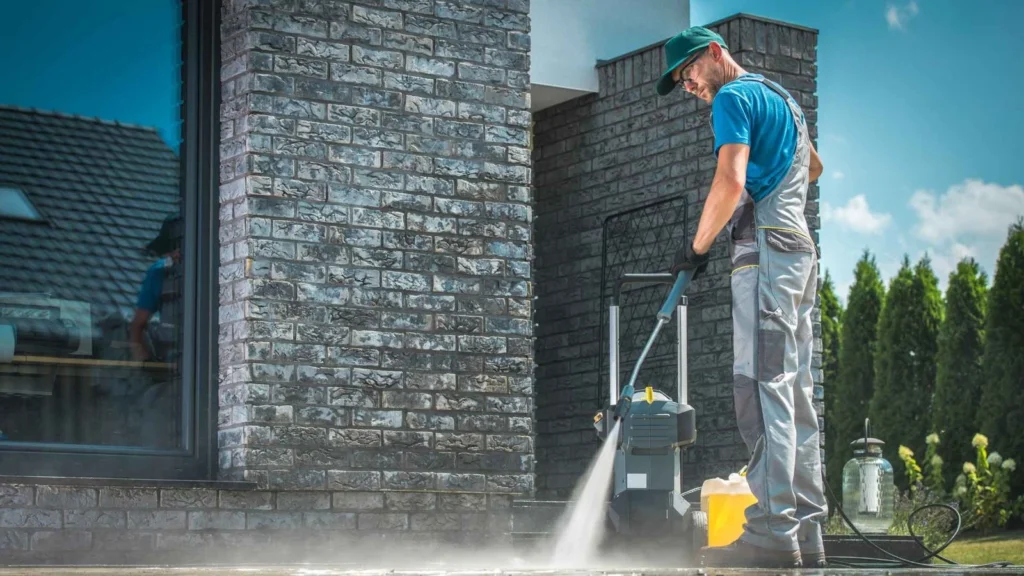 a man cleaning a sidewalk with a pressure washer